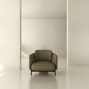Modern beige armchair in minimalist interior with neutral walls and soft natural light